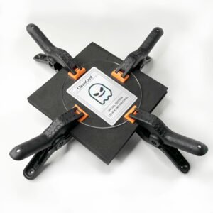 CleanCard Trading card flattening kit in use clamping a bent Pokemon card to repair dents, correct creases, and restore flatness using pressure clamps and acrylic plates.